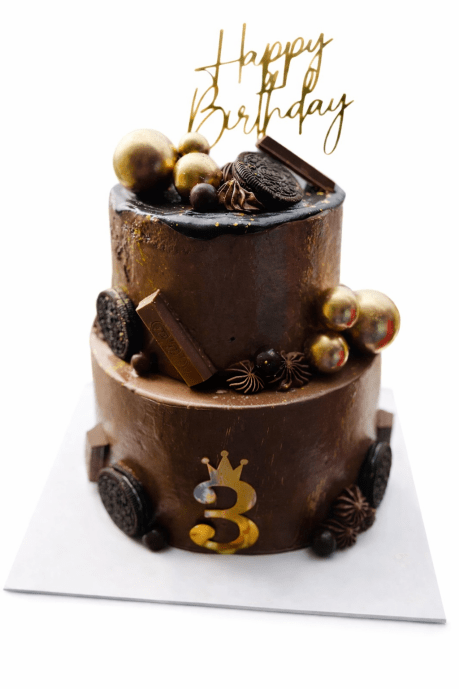 Rich Oreo Chocolate layered cake with gold drip and biscuit toppings